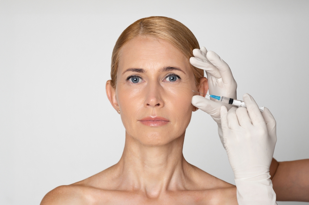 Close up of a middle-aged woman receiving Botox injections to her cheeks to smooth fine lines and wrinkles.